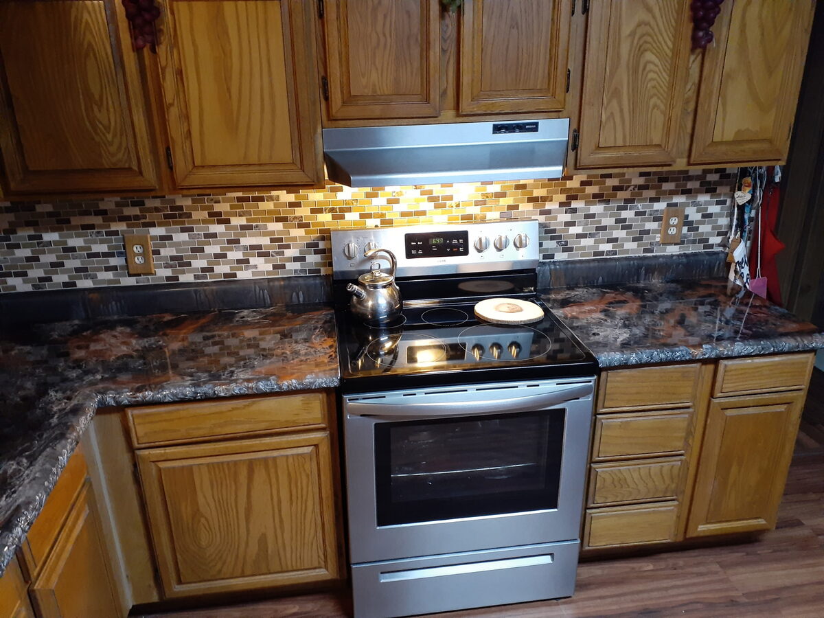 Kitchen countertop after resurfacing — high-gloss black and copper marble-look poured finish